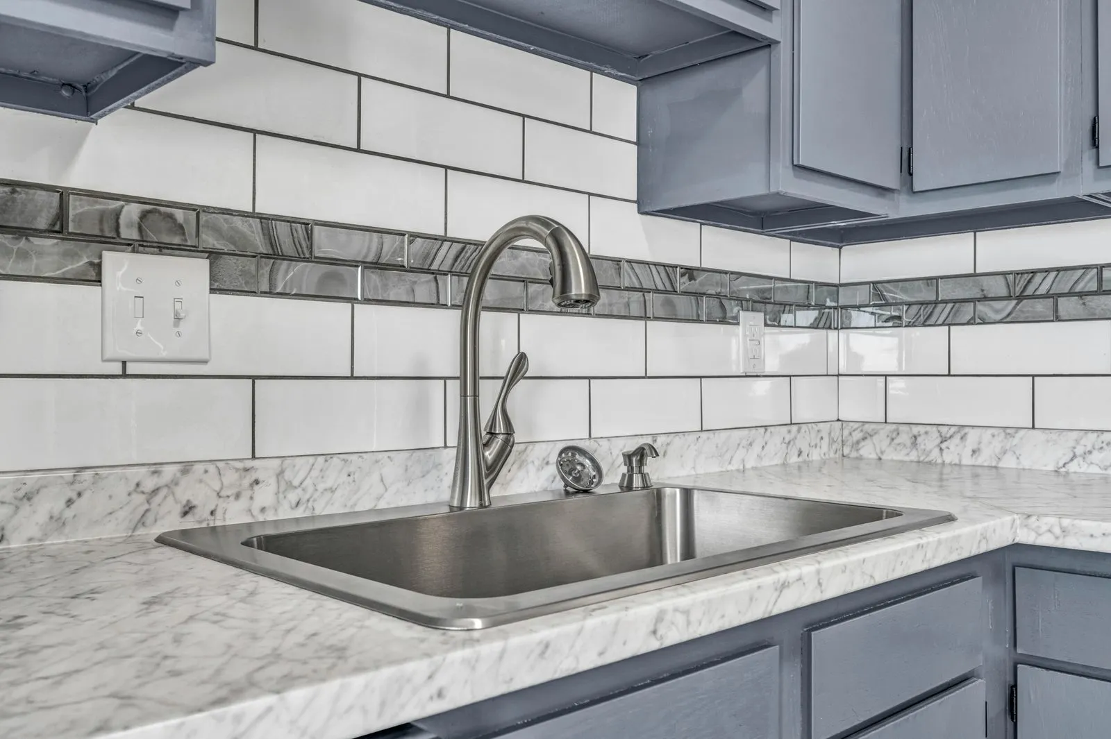 Grouted subway tile backsplash over the sink
