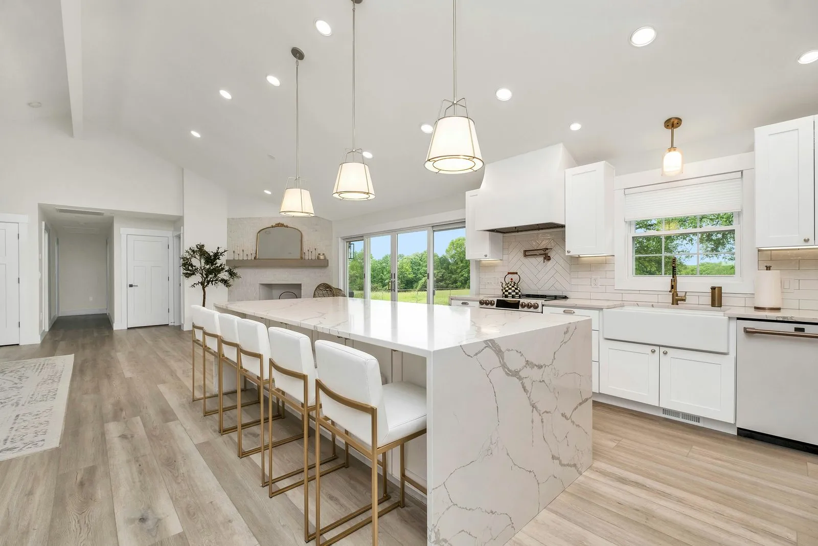 Kitchen with a waterfall quartz island and pendant lights